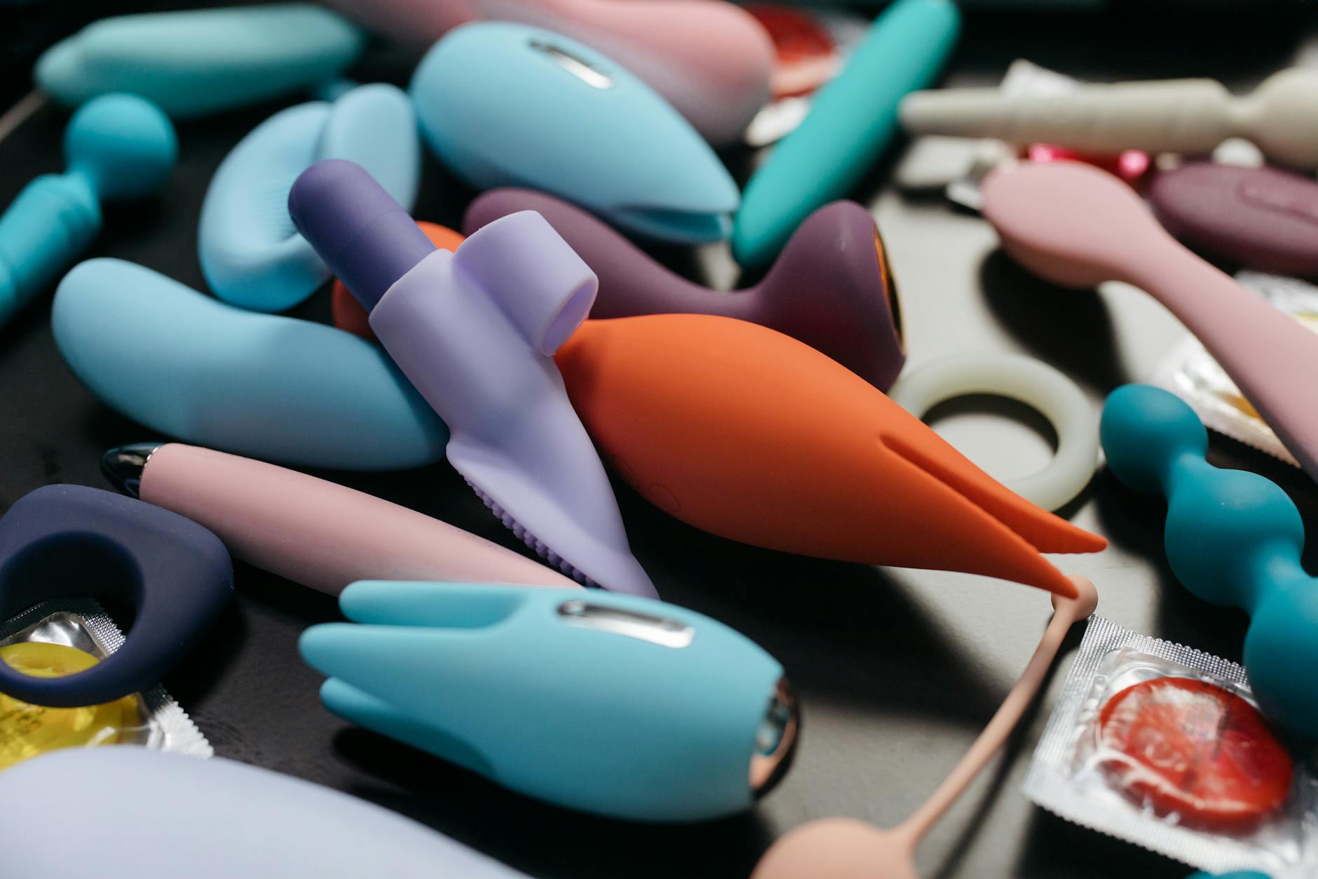 Person holding clitoral vibrators thoughtfully, exploring pleasure options