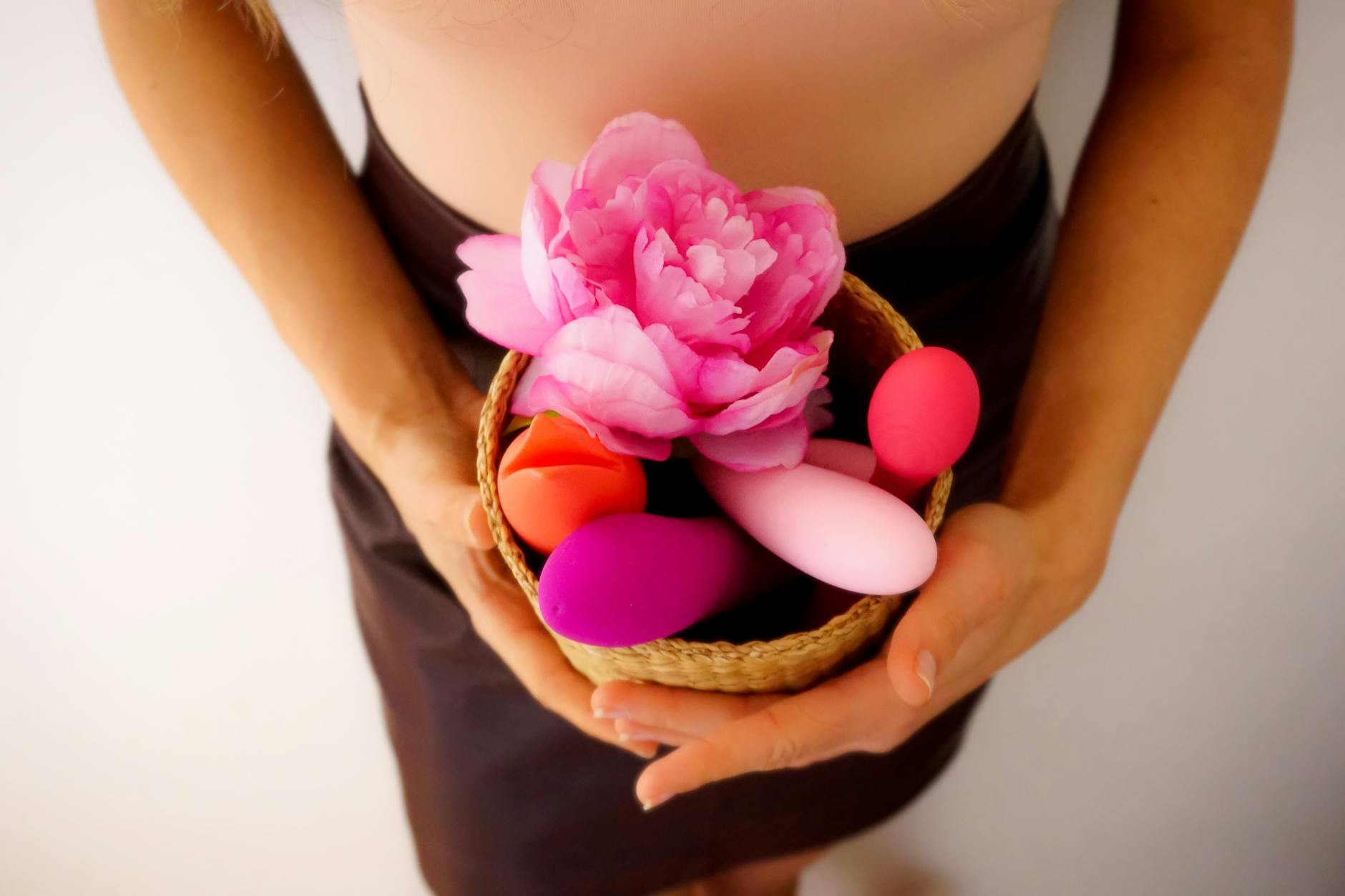 Pink vibrator on purple background with heart confetti and candles for intimate moments